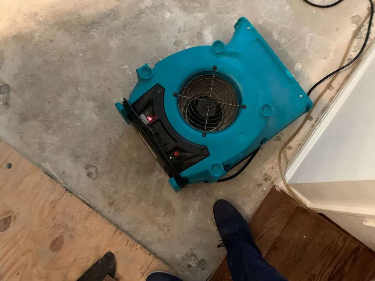 Air mover drying subfloor during Commercial Water Damage Restoration in Emmett